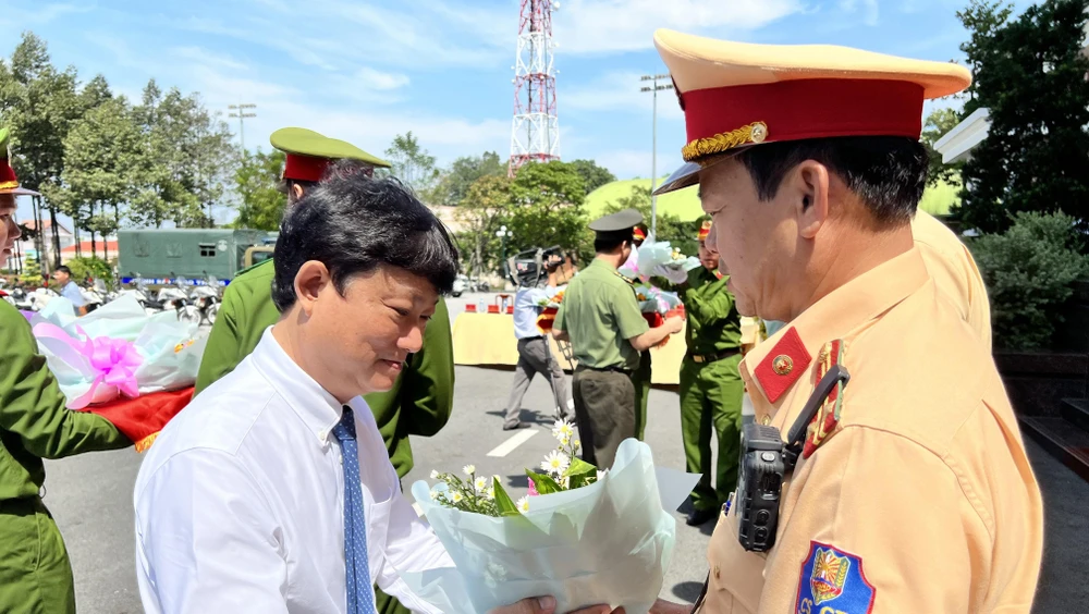 Ông Võ Văn Minh, Chủ tịch UBND tỉnh Bình Dương tặng hoa động viên các tổ tuần tra trong lễ ra quân. Ảnh: LÊ ÁNH