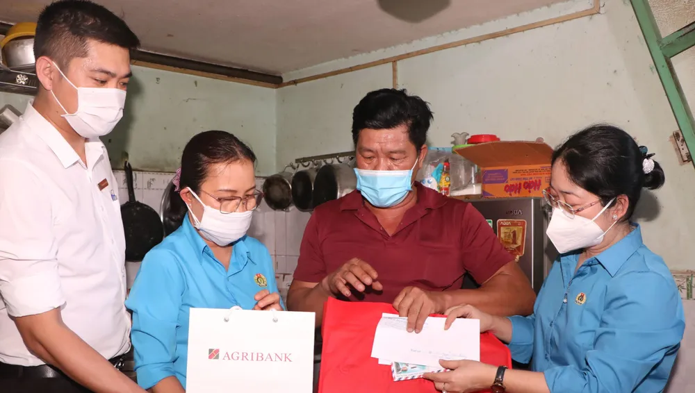 Bà Nguyễn Kim Loan, Chủ tịch Liên đoàn lao động tỉnh Bình Dương (phải) tặng quà cho công nhân có hoàn cảnh khó khăn. Ảnh: ĐT