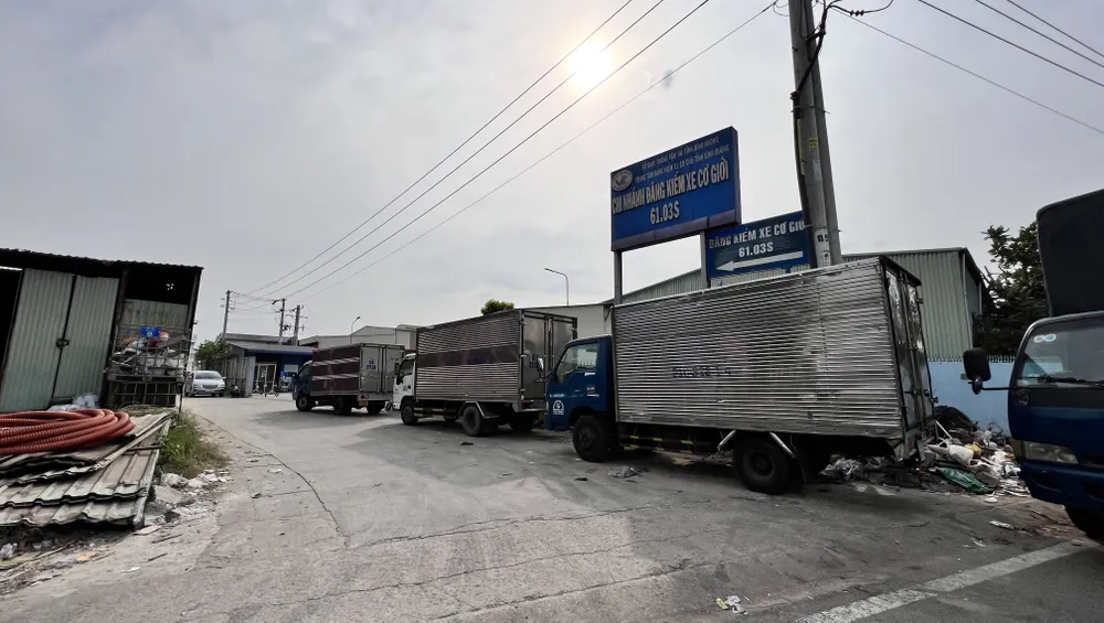Xe đậu hàng dài trước Trung tâm đăng kiểm xe cơ giới 61-03S nằm trên đường Mỹ Phước-Tân Vạn. Ảnh: LÊ ÁNH