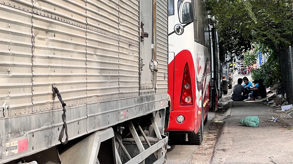 Các tài xế ngồi chờ bên lề đường trước cổng Trung tâm đăng kiểm xe cơ giới 61-04D (phường An Thạnh, TP Thuận An). Ảnh: LÊ ÁNH