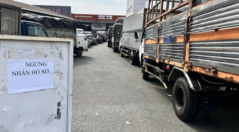 Các phương tiện nối đuôi nhau, xếp hàng dài trước Trung tâm đăng kiểm xe cơ giới 61-01S nằm trên Đại lộ Bình Dương (TP Thủ Dầu Một), bảng ngưng nhận hồ sơ đã được đặt trước cổng từ buổi sáng. Ảnh: LÊ ÁNH