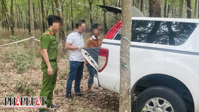 Lực lượng công an khám nghiệm chiếc xe ô tô mà nghi phạm cất giấu trong rừng cao su. Ảnh: LA