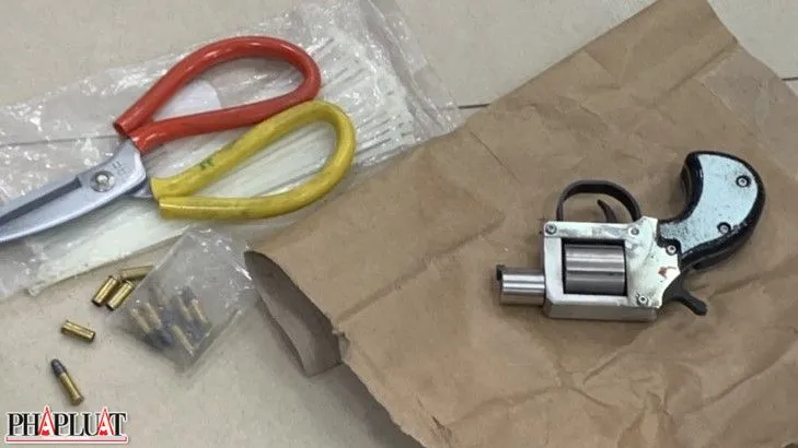 Khẩu súng và số đạn tên cướp dùng để uy hiếp cướp tiền tại ngân hàng. Ảnh: LÊ ÁNH Khẩu súng và số đạn tên cướp dùng để uy hiếp cướp tiền tại ngân hàng. Ảnh: LÊ ÁNH