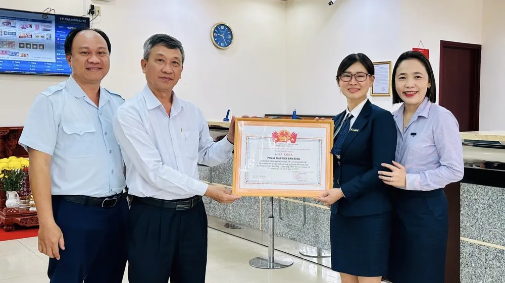 Ông Võ Đình Phong tặng giấy khen cho tập thể phòng giao dịch của Ngân hàng Sacombank Bàu Bàng. Ảnh: LA