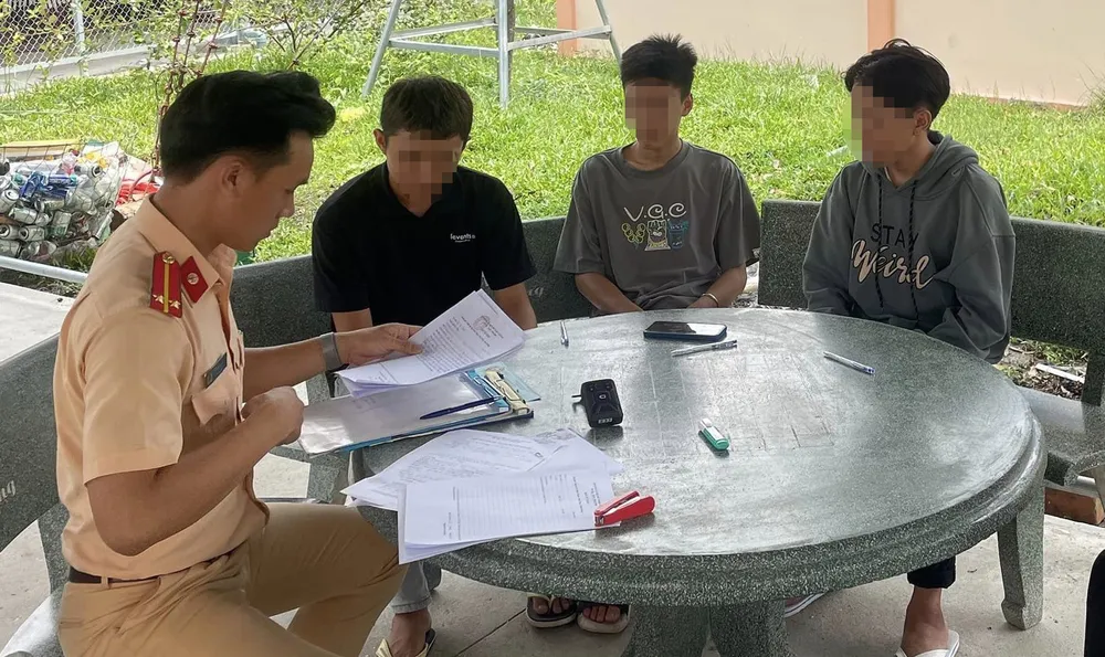 Cảnh sát giao thông mời các thanh niên liên quan lên làm việc. Ảnh: CACC