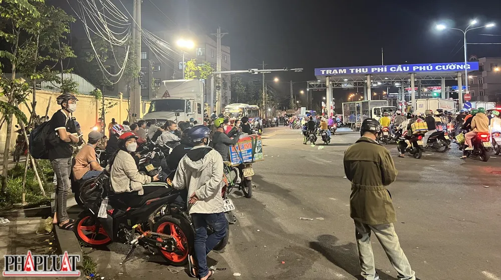 Người dân thấm mệt vì cả đoạn đường dài ùn tắc, đành bất lực đứng chờ ngay chân cầu Phú Cường.