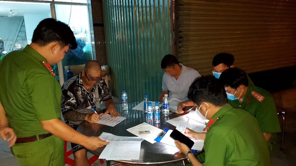 Lực lượng công an làm việc với người vi phạm. Ảnh: LA Lực lượng công an làm việc với người vi phạm. Ảnh: LA