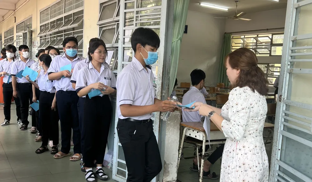 Các thí sinh làm thủ tục vào phòng thi. Ảnh: LÊ ÁNH