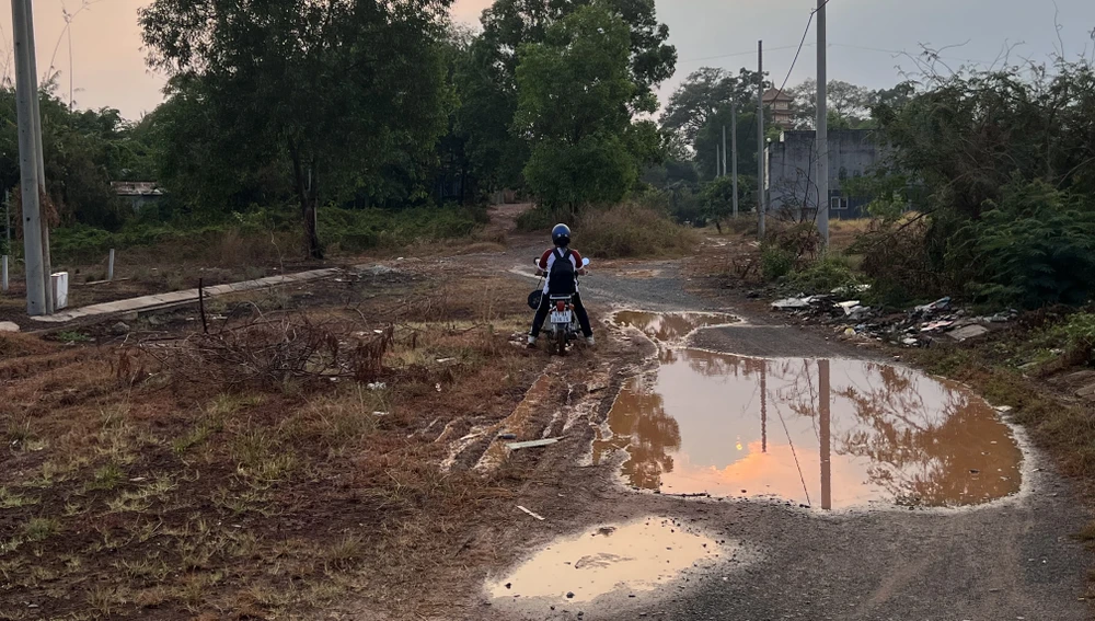 Học sinh đi học qua những con đường lầy lội. Ảnh: LÊ ÁNH