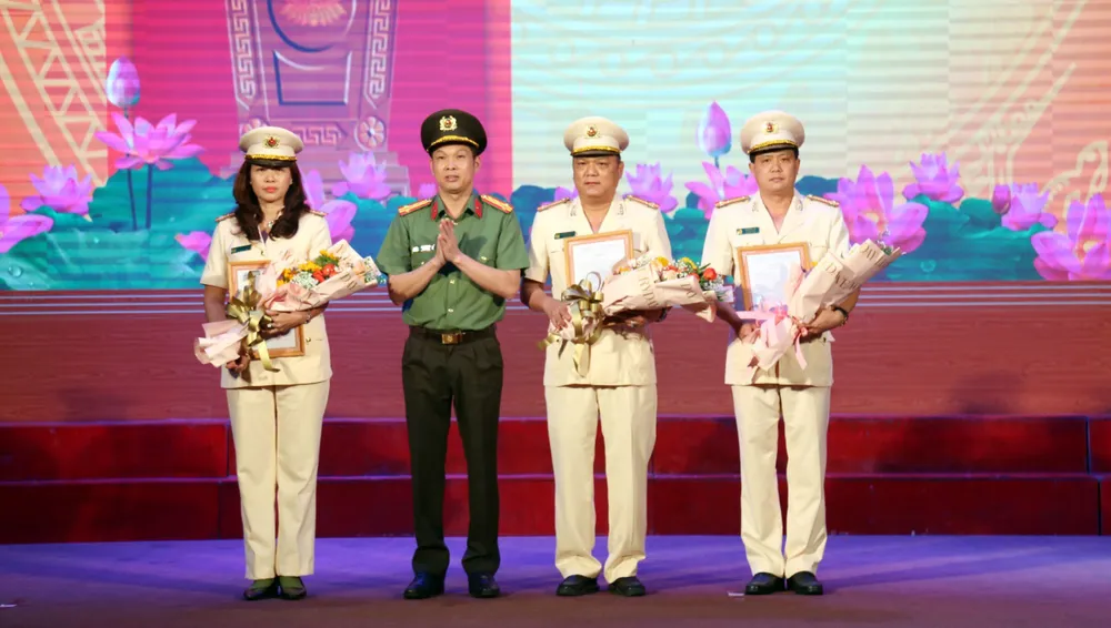 Giám đốc Công an tỉnh Bình Dương trao quyết định cho ba trưởng phòng nghiệp vụ phải sát nhập. Ảnh: LA