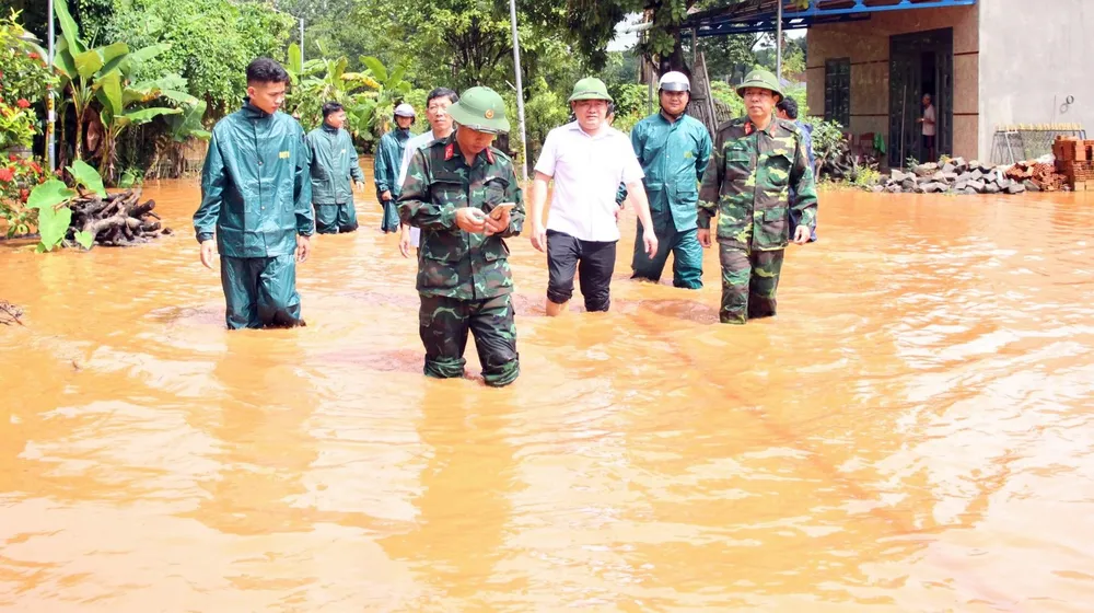 Ông Lê Văn Chung (áo trắng), Phó Chủ tịch UBND huyện Phú Riềng trực tiếp đến hiện trường chỉ đạo hỗ trợ người dân bị ngập. Ảnh: PY bình phước ngập nặng (8).jpg