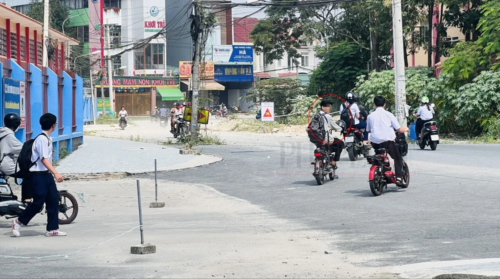 Một học sinh trường THPT An Mỹ có mũ bảo hiểm nhưng treo trước xe không đội. Ảnh: LA z4860533639933_3f6dedeac123ea37f7889b1d78132848.jpg
