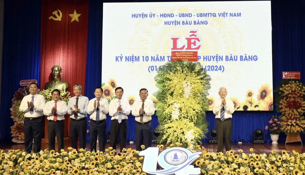 Ông Nguyễn Minh Triết, Nguyên Chủ tịch nước tặng hoa chúc mừng chính quyền, nhân dân huyện Bàu Bàng. Ảnh: HẢI NHI công nghiệp