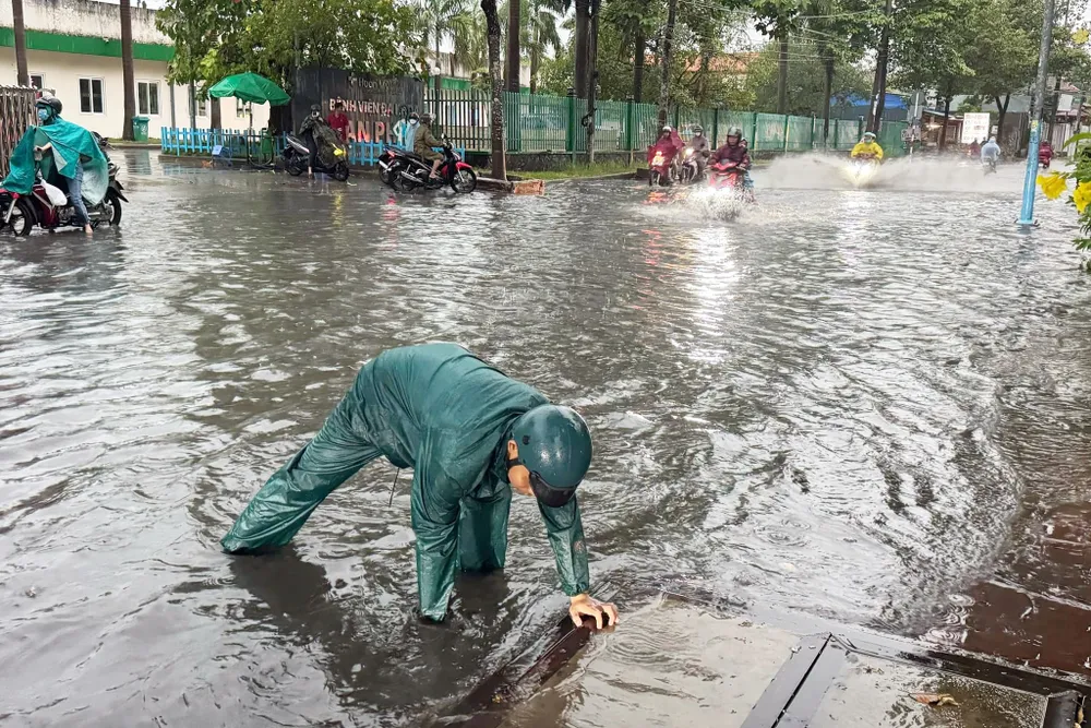 Lực lượng chức năng cố gắng khơi thông cống bị tắc nghẽn để nước rút nhanh. mưa lớn (1).jpg