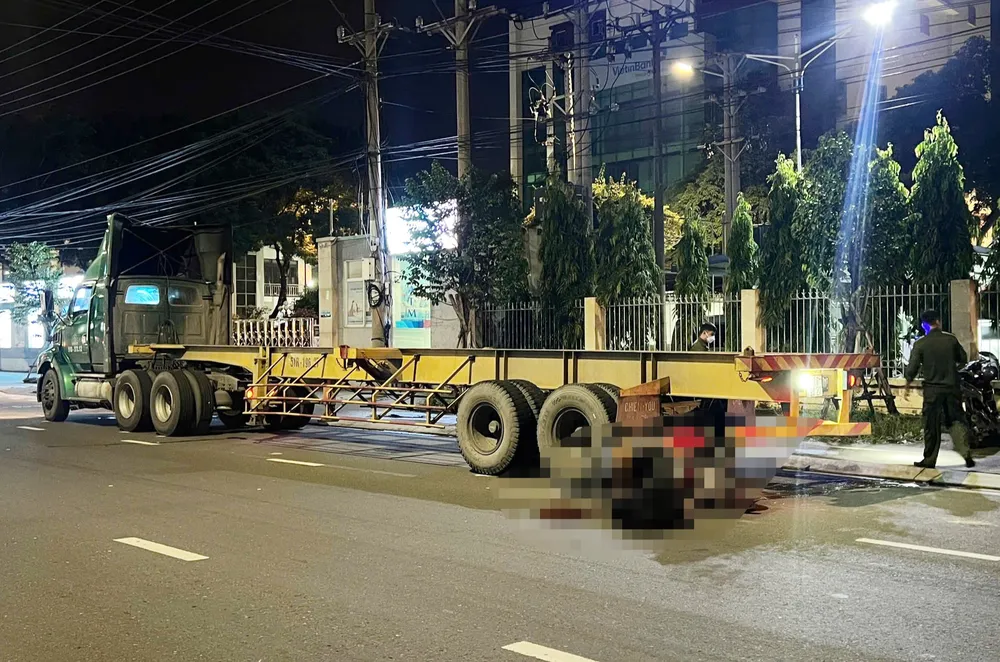 Hiện trường hai người đàn ông đã tử vong phía đuôi xe đầu kéo. Ảnh: KD xe đầu kéo.jpg