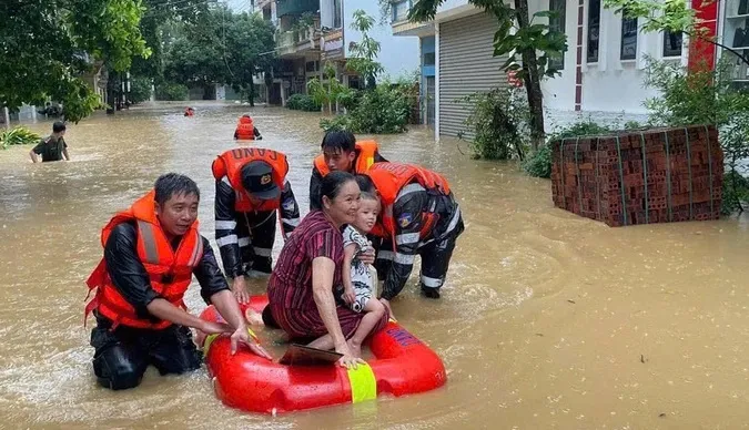Lực lượng chức năng đưa người dân tại TP Lào Cai ra khỏi vùng ngập. Ảnh: VỮNG NGUYỄN bão số 3.jpg