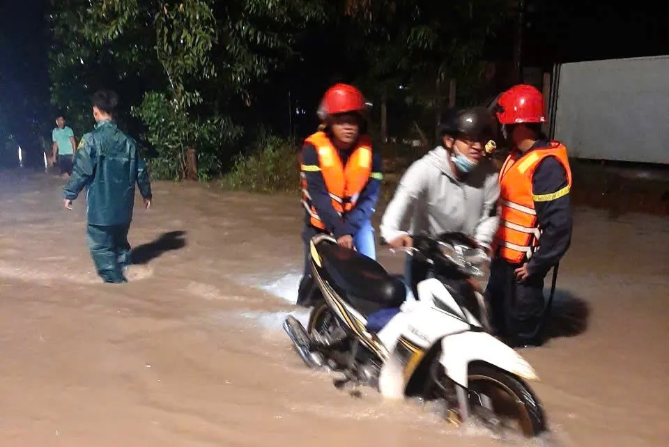 Lực lượng chức năng huyện Dầu Tiếng hỗ trợ người dân an toàn đi qua vùng bị ngập nước. Ảnh: CADT cống thoát nước (1).jpg