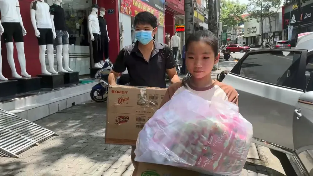 Các em nhỏ cùng người thân mang nhu yếu phẩm đến các điểm tập kết để ủng hộ cho đồng bào miền Bắc. ủng hộ đồng bào (2).jpg