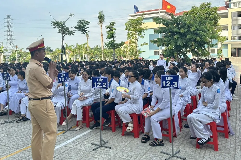 Lực lượng Cảnh sát giao thông, Công an TP Tân Uyên tuyên truyền cho học sinh nắm rõ các quy định khi tham gia giao thông, đặc biệt là hướng dẫn đảm bảo an toàn khi mưa lớn. Ảnh: CA an toàn giao thông (1).jpg