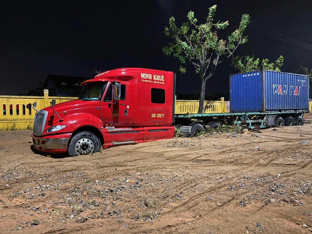 Xe container bị đất cát phủ kín gầm. Ảnh: HH