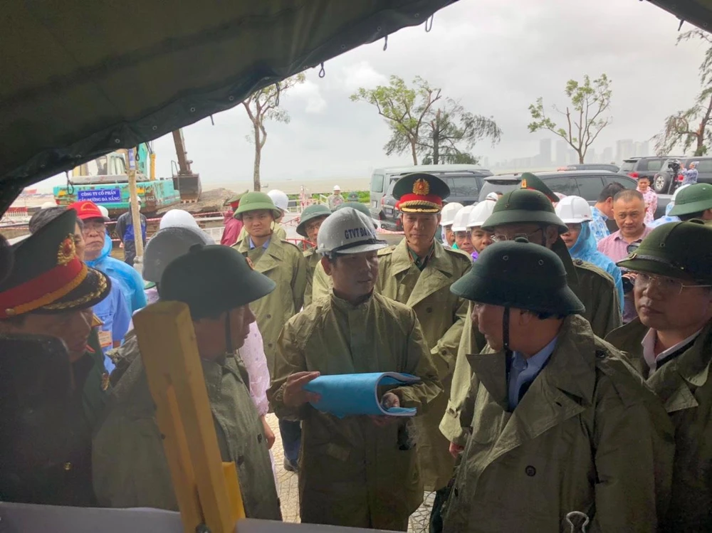 Chủ tịch nước Nguyễn Xuân Phúc nghe báo cáo khắc phục sạt lở đường lên Sơn Trà. Ảnh: NGÔ QUANG.