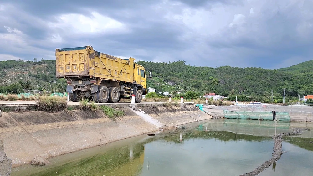 Đường đan bê tông đi qua cánh đồng muối đang bị dàn xe tải trọng lớn "uy hiếp". Ảnh: MINH TRƯỜNG.