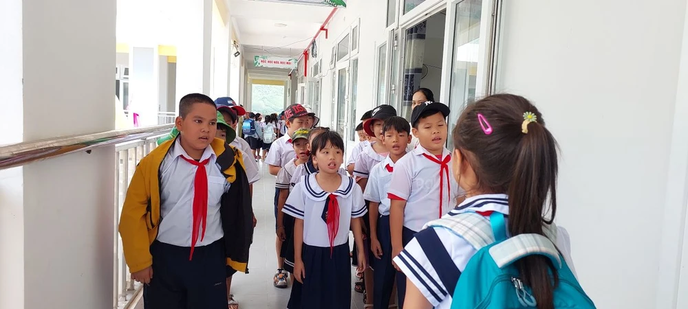 Các em xếp hàng ra về sau mỗi buổi học. Ảnh: MT. di học.jpg