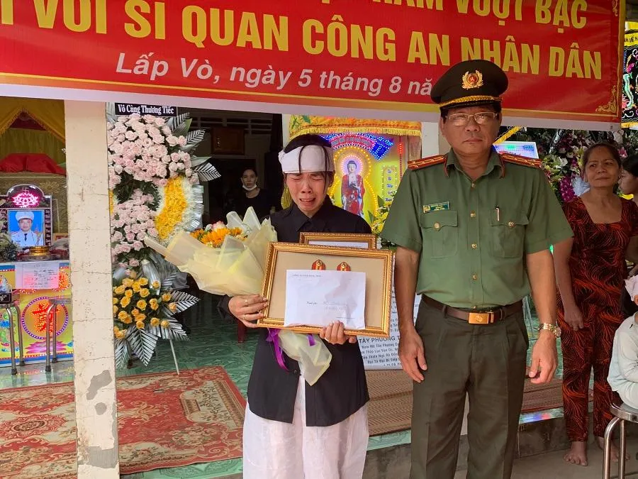 Vợ Thiếu tá Hồ Tấn Dương xúc động khi nhận quyết định thăng cấp bậc hàm của chồng.