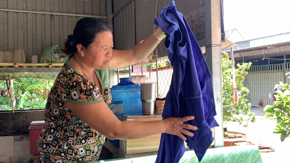 Bà Nguyễn Thị Tuyền sắp xếp quần áo để trường hợp có người bơi qua sông thì cho họ thay Bà Nguyễn Thị Tuyền sắp xếp quần áo để trường hợp có người bơi qua sông thì cho họ thay