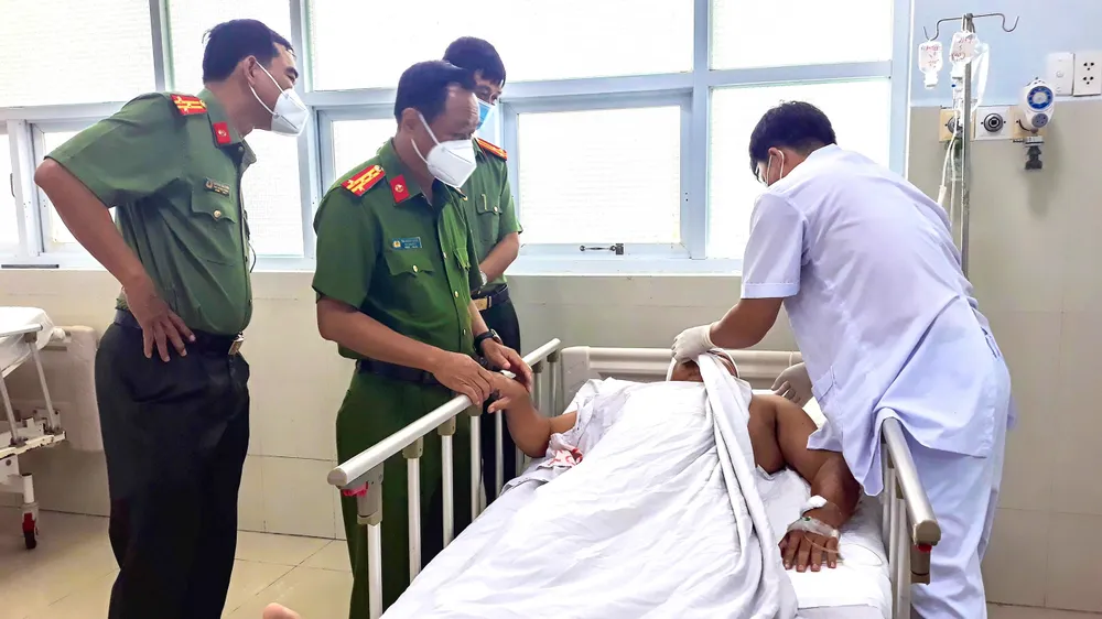 Đại tá Trà Quang Thanh, Phó Giám đốc Công an tỉnh Vĩnh Long, thăm hỏi Trưởng Công an xã bị chém khi đi làm nhiệm vụ. Ảnh: CA chem-cong-an-xa.jpg