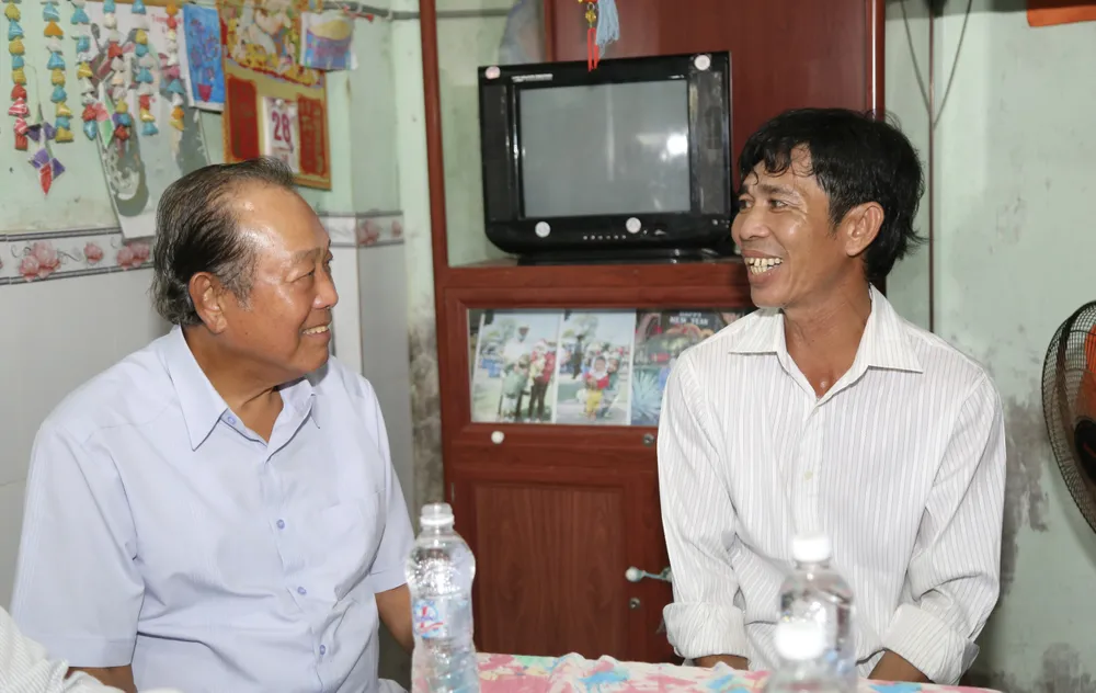 Nguyên Phó Thủ tướng Thường trực Trương Hòa Bình thăm hỏi, động viên ngư dân Danh Toàn. Ảnh: HOÀNG GIANG tham-ngu-dan-7.jpg