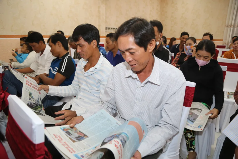 Các ngư dân thích thú khi đọc báo Pháp Luật TP.HCM. Ảnh: CHÂU ANH trao-qua.jpg
