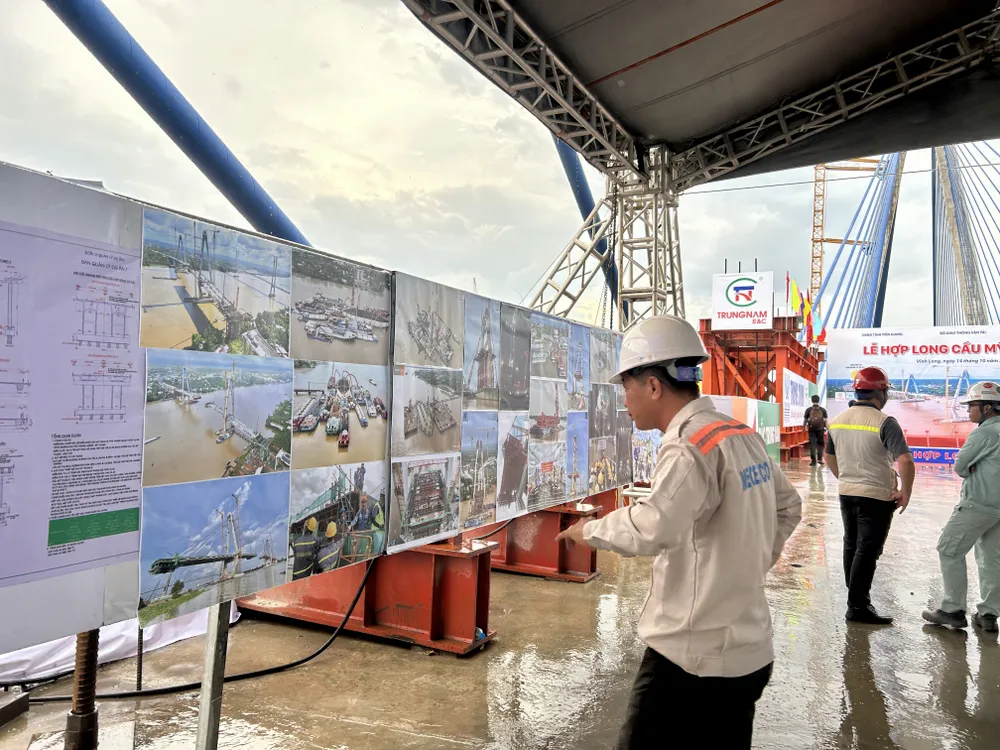 Công nhân đang ngắm nhìn lại hình ảnh cầu Mỹ Thuận 2 từ những ngày đầu thi công đến hôm nay. Hop-long.jpeg