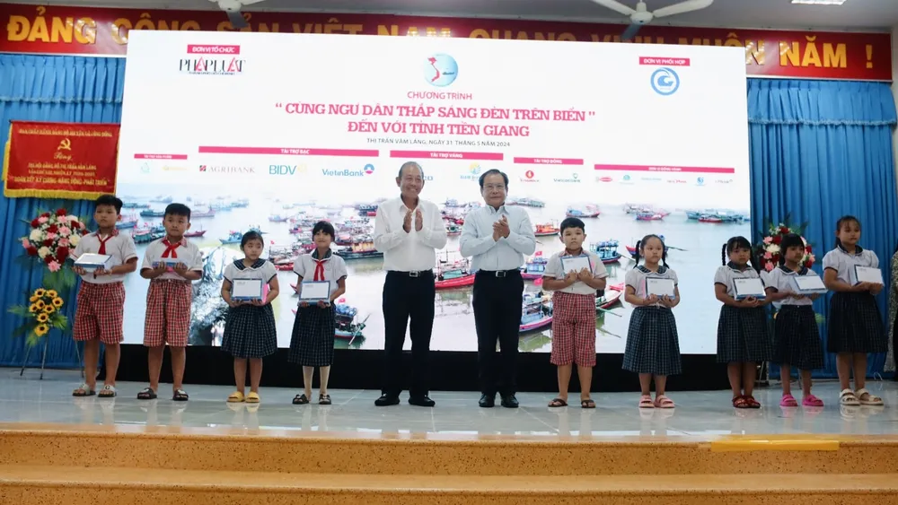 Ông Trương Hòa Bình, nguyên Ủy viên Bộ Chính trị, nguyên Phó Thủ tướng thường trực Chính phủ cùng ông Mai Ngọc Phước, Tổng Biên tập báo Pháp Luật TP.HCM, Trưởng ban Chỉ đạo chương trình, trao quà cho các em học sinh trao-qua-tien-giang-19.jpg