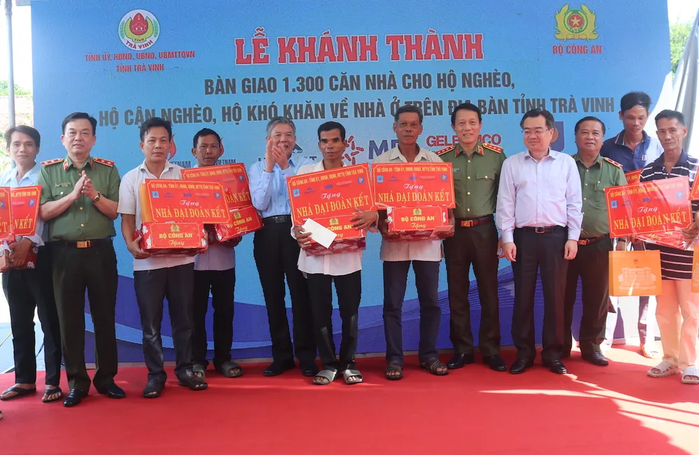 Bộ trưởng Bộ Công an Lương Tam Quang cùng Bộ trưởng Bộ Xây dựng Nguyễn Thanh Nghị và Bí Thư Tỉnh uỷ Trà Vinh Ngô Chí Cường và các hộ dân tại lễ khánh thành bộ công an trao nhà cho người nghèo ở trà vinh