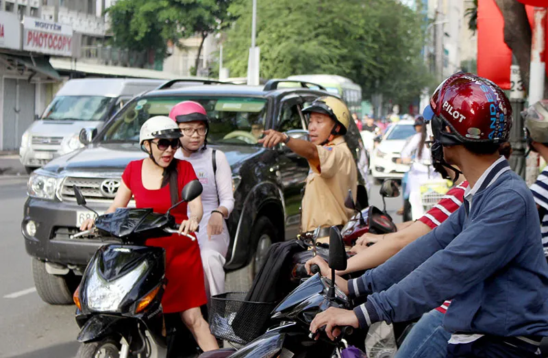 CSGT hướng dẫn phụ huynh đưa con em đến trường đúng luật. Ảnh: LÊ THOA