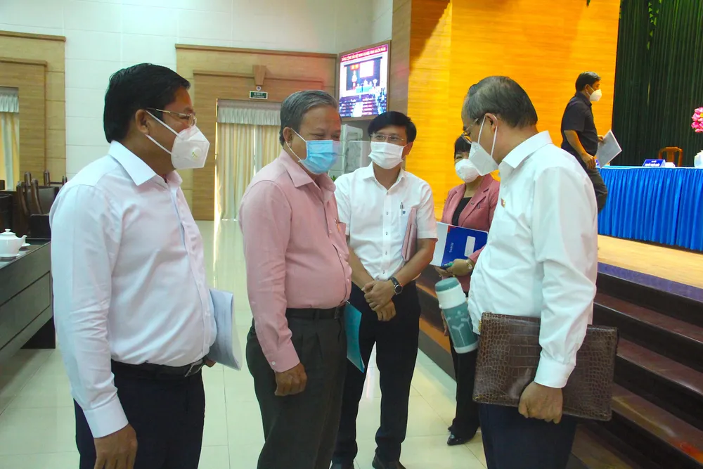 Các đại biểu trao đổi bên lề buổi tiếp xúc cử tri. Ảnh: LÊ THOA