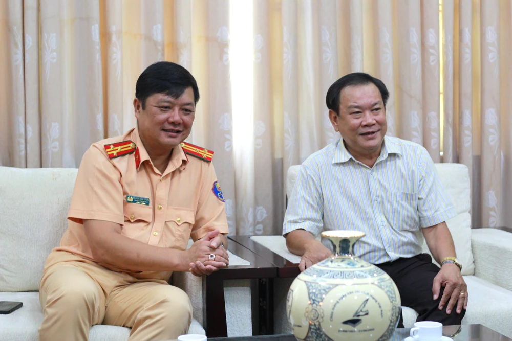 Tổng biên tập báo Pháp Luật TP.HCM và Trưởng phòng CSGT TP.HCM trao đổi thân tình nhân ngày Báo chí Cách mạng Việt Nam. Ảnh: NGUYỄN TIẾN