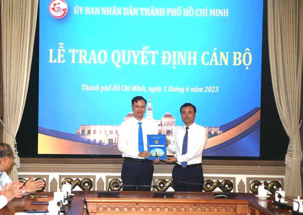 Phó Chủ tịch UBND TP.HCM Bùi Xuân Cường trao quyết định cho ông Bùi Anh Huấn. Ảnh: HÀ THƯ