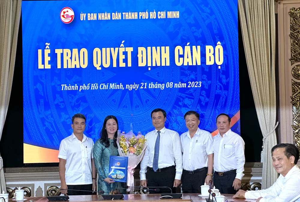 Phó Chủ tịch UBND TP.HCM Bùi Xuân Cường trao quyết định cho bà Huỳnh Thị Xuân Mai. Ảnh: L.THOA