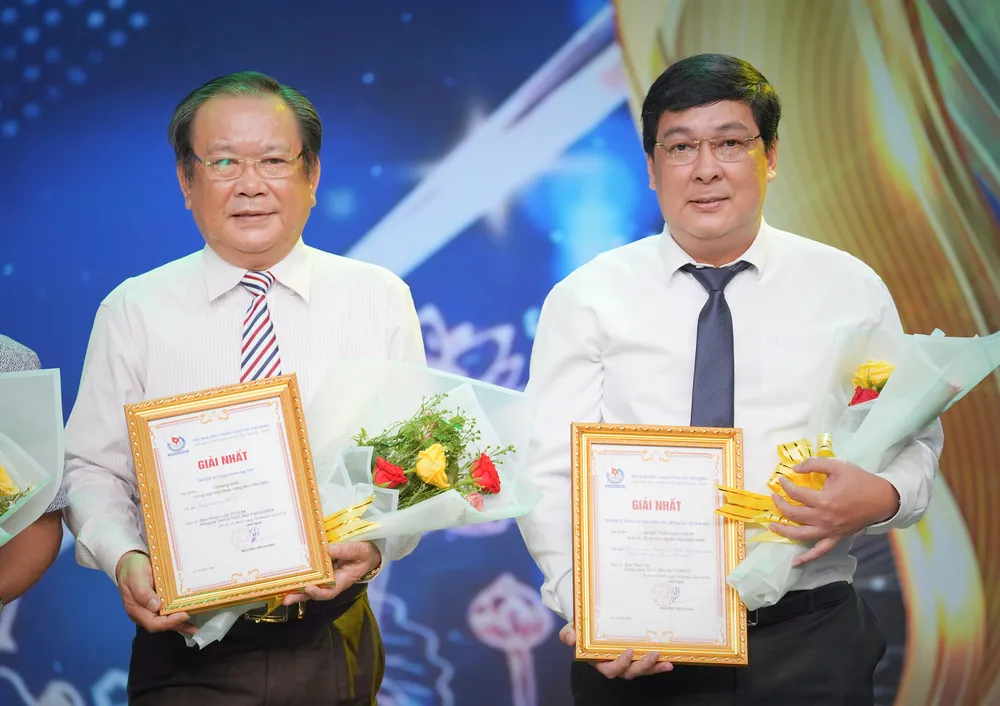 Tổng Biên tập báo Pháp Luật TP.HCM Mai Ngọc Phước và Phó Tổng biên tập báo Pháp Luật TP.HCM Nguyễn Thái Bình nhận giải Nhất công trình tập thể "Cùng ngư dân thắp sáng đèn trên biển". Ảnh: THUẬN VĂN bao-phap-luat-tp.hcm-7.jpg
