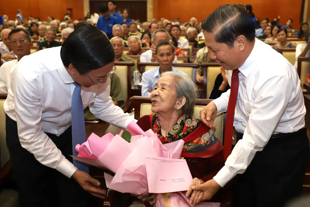 Chủ tịch UBND TP.HCM Phan Văn Mãi (bên trái) tặng hoa cho Mẹ Việt Nam Anh hùng. Ảnh: HÀ THƯ gia-dinh-chinh-sach-4.jpg