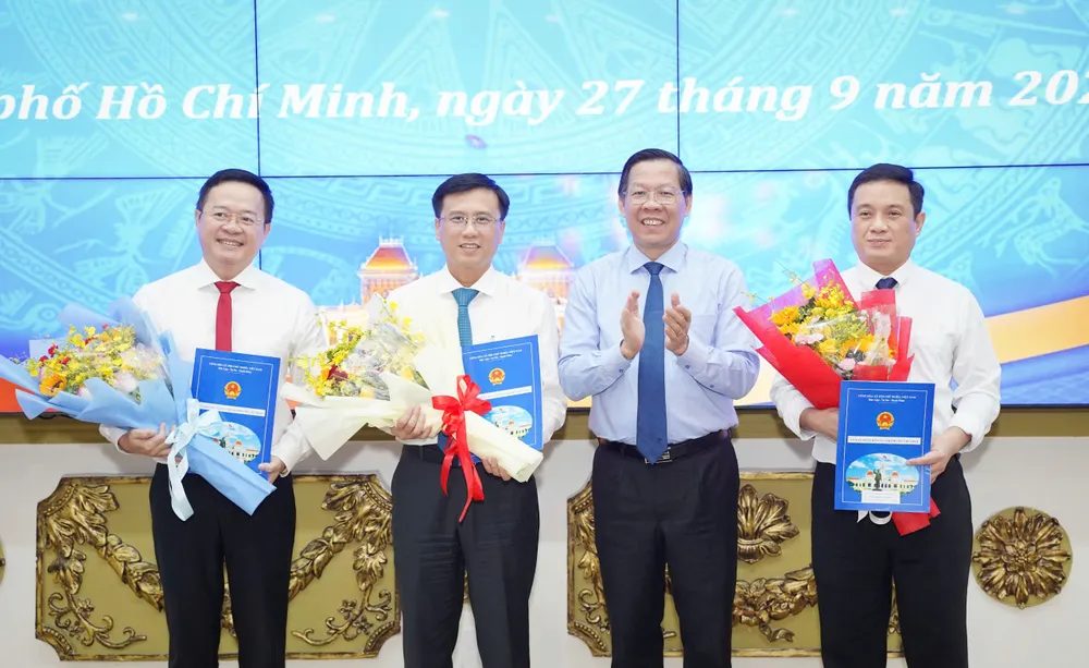 Chủ tịch UBND TP.HCM Phan Văn Mãi trao quyết định cho ông Đinh Khắc Huy, Nguyễn Minh Nhựt và Nguyễn Trung Anh (theo thứ tự từ trái sang). Ảnh: THUẬN VĂN trao-quyet-dinh-1.jpg