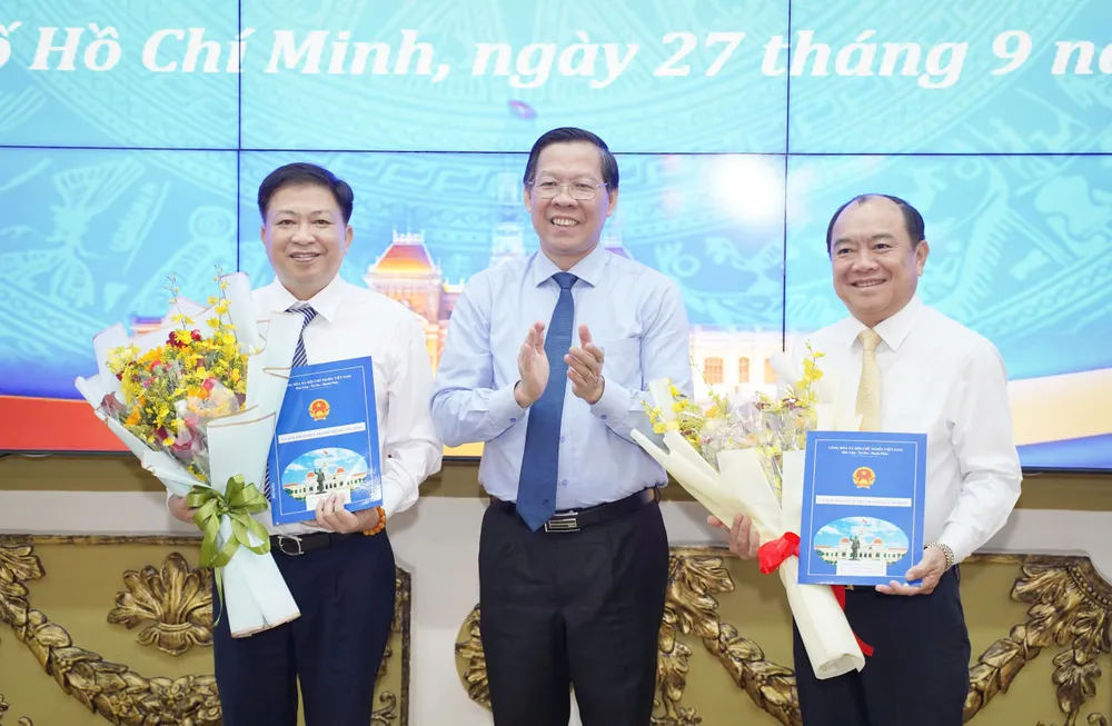 Chủ tịch UBND TP.HCM Phan Văn Mãi trao quyết định cho ông Võ Thành Khả (bên trái) và ông Lê Văn Thành (bên phải). Ảnh: THUẬN VĂN trao-quyet-dinh-2.jpg