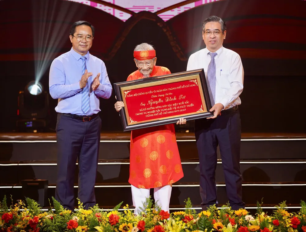 Chủ tịch UBND TP.HCM Nguyễn Văn Được và Chủ tịch Ủy ban MTTQ Việt Nam TP.HCM trao bảng vàng tôn vinh cho nhà nghiên cứu Nguyễn Đình Tư. Ảnh: THUẬN VĂN Chủ tịch Nguyễn Văn Được: Cách làm đột phá, 'xé rào, bung ra' đã mang lại thành tựu to lớn cho TP.HCM