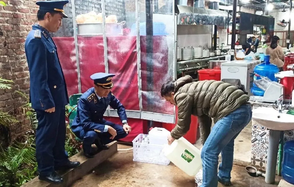 Lực lượng quản lý thị trường Lạng Sơn giám sát hộ kinh doanh tiêu huỷ rượu không rõ nguồn gốc. Ảnh: QLTT Lạng Sơn