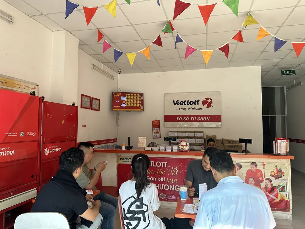 Đông đảo người chơi nán lại điểm bán hàng để dò số Keno.