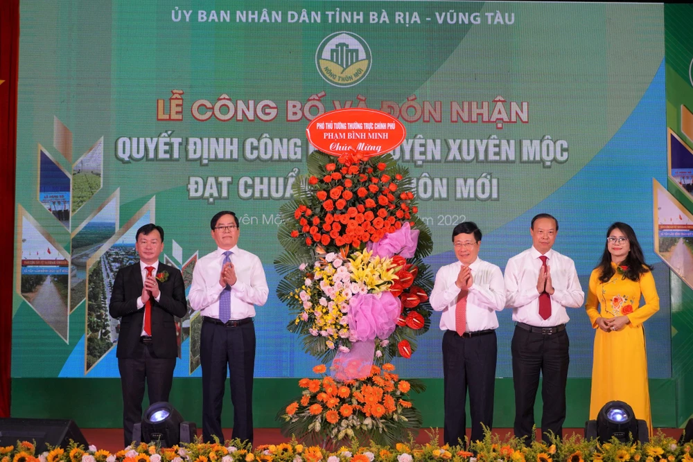 Phó Thủ tướng Phạm Bình Minh tặng hoa cho huyện Xuyên Mộc tại buổi lễ-Ảnh:TA