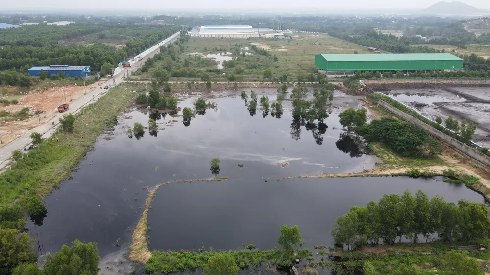 Một đoạn tường rào hồ chứa chất thải bị vỡ khiến nước tràn ra khu đất lân cận và suối Giao Kèo, hướng về đập Châu Pha-Ảnh:HS Một đoạn tường rào hồ chứa chất thải bị vỡ khiến nước tràn ra khu đất lân cận và suối Giao Kèo, hướng về đập Châu Pha-Ảnh:HS