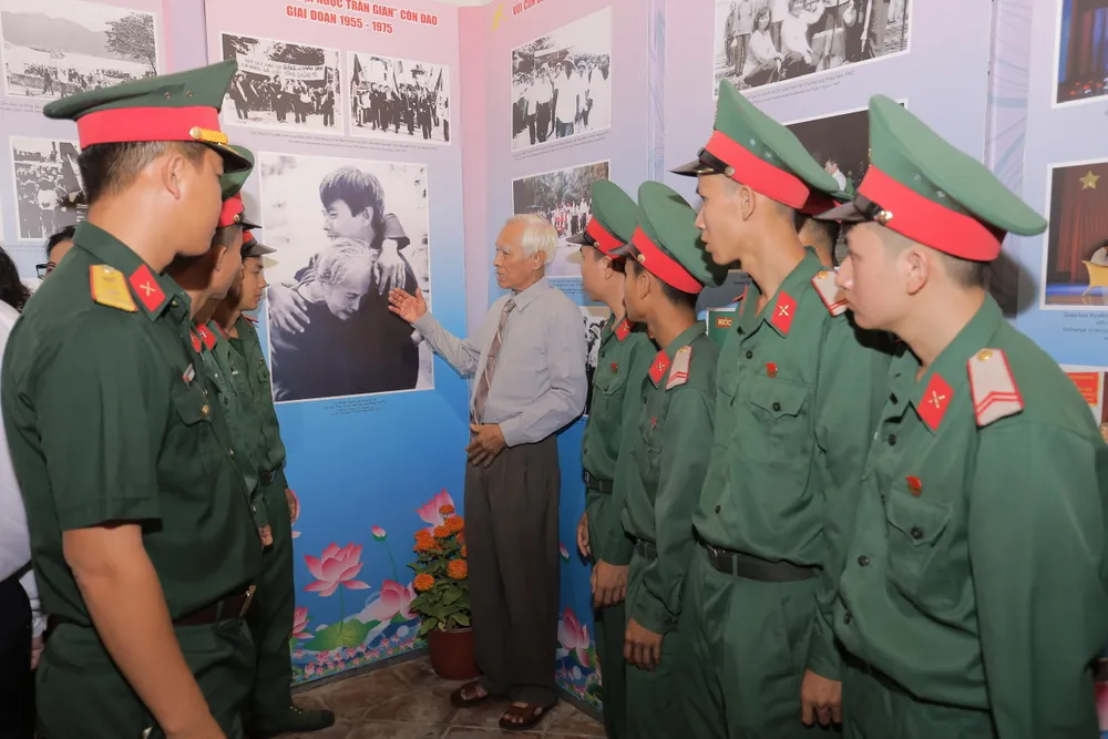 Cựu tù Chính trị Lê Văn Thức, nhân vật trong bức ảnh &quot;Mẹ con ngày gặp mặt&quot; đang giới thiệu về bức ảnh chụp mình với các chiến sỹ huyện Côn Đảo. Ảnh: MC